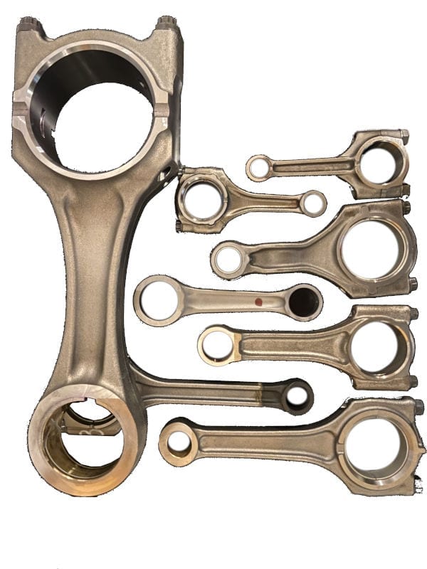 Several connecting rods of different sizes lie on a table.