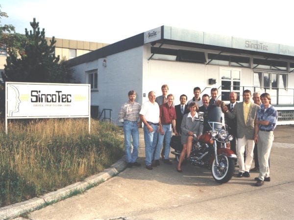 Group of people with a motorcycle in front of the SincoTec company.