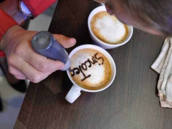 Jemand schreibt das Wort SincoTec auf einen Kaffee.