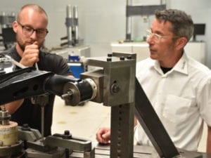 Two people work on a testing machine.