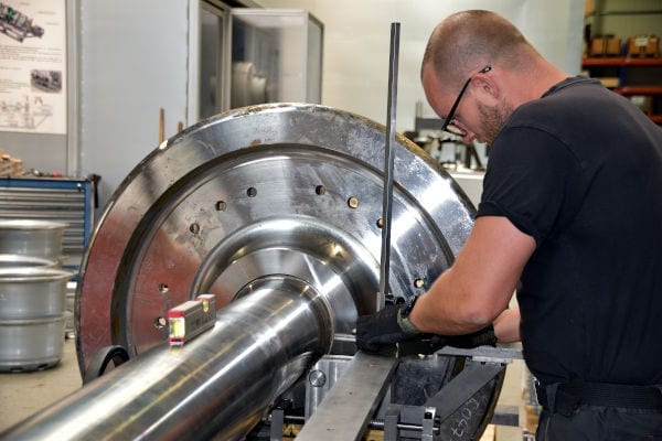 Mann, der im Labor an der Radachsenmaschine arbeitet.